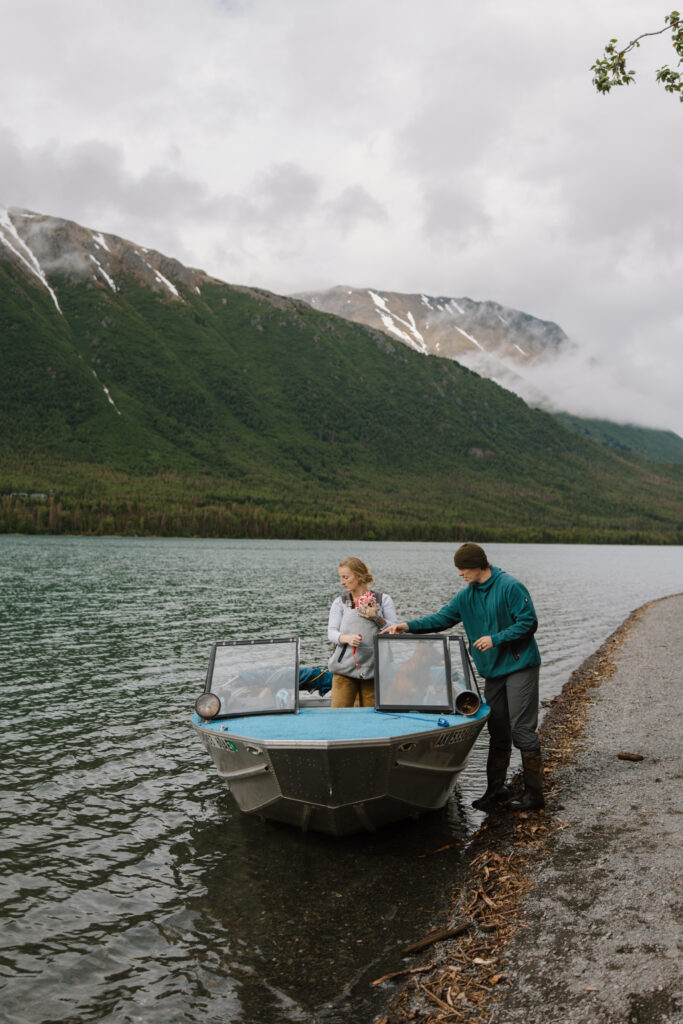 Family loading onto a boat at Kenai Lake Alaska with mom, dad, baby, and their dog