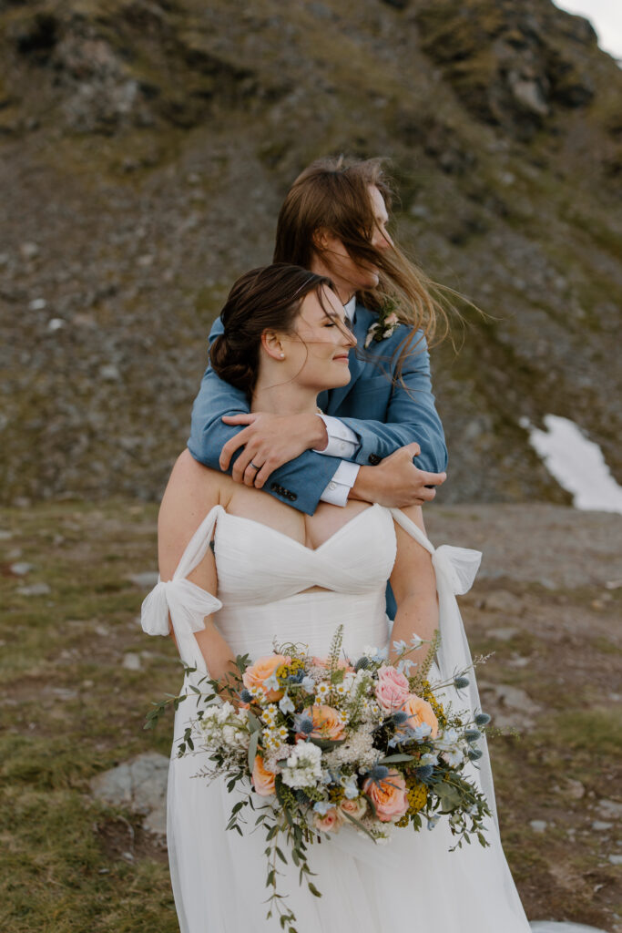 Bride and groom gazing into the distance with windswept hair during their Hatcher Pass elopement at Summit Lake