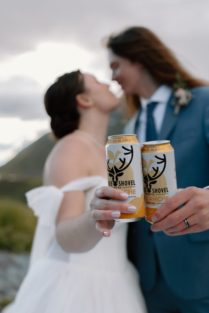 Bride and groom cheersing Double Shovel cider cans during their Hatcher Pass elopement celebration