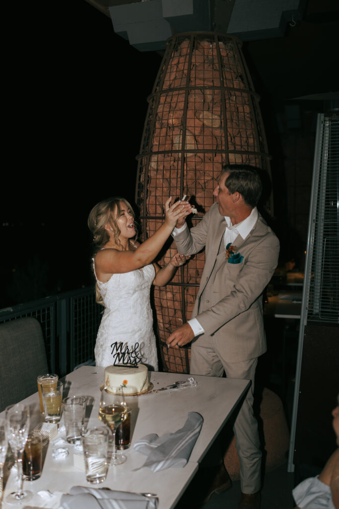 Bride and groom feeding each other wedding cake at their Sedona Arizona elopement celebration at Broome and Orchard