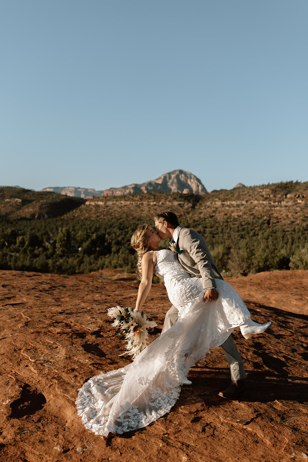 Groom dipping bride for a kiss at sunset during their Sedona Arizona elopement at Secret Slickrock
