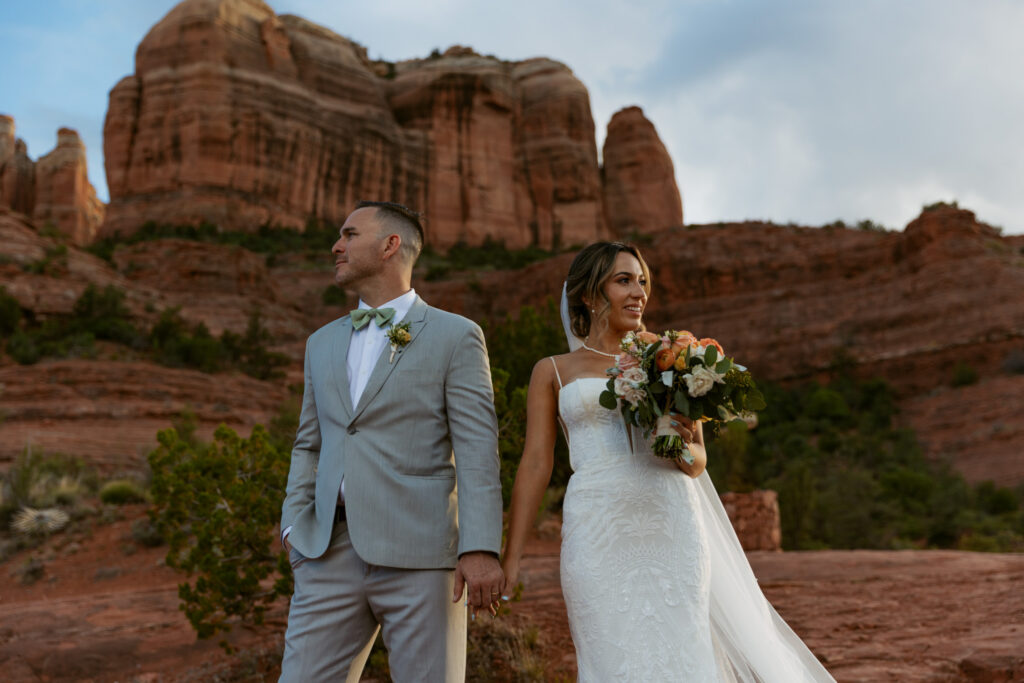 Bride and groom holding hands and looking out at the view from Cathedral Rock trail during their Sedona Arizona elopement