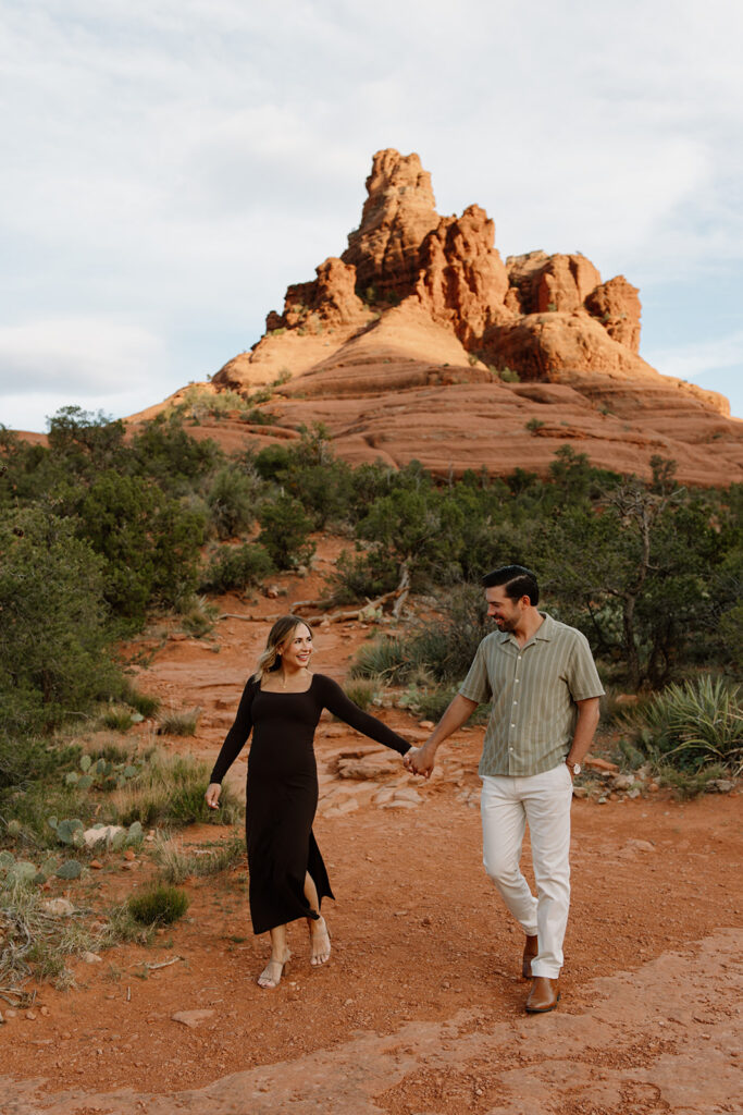 Couple holding hands and smiling on the Bell Rock trail in Sedona Arizona