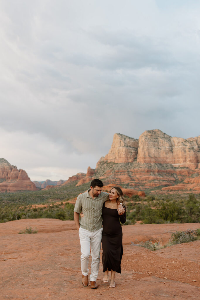 Couple walking together with his arm over her shoulder on the Bell Rock trail in Sedona Arizona
