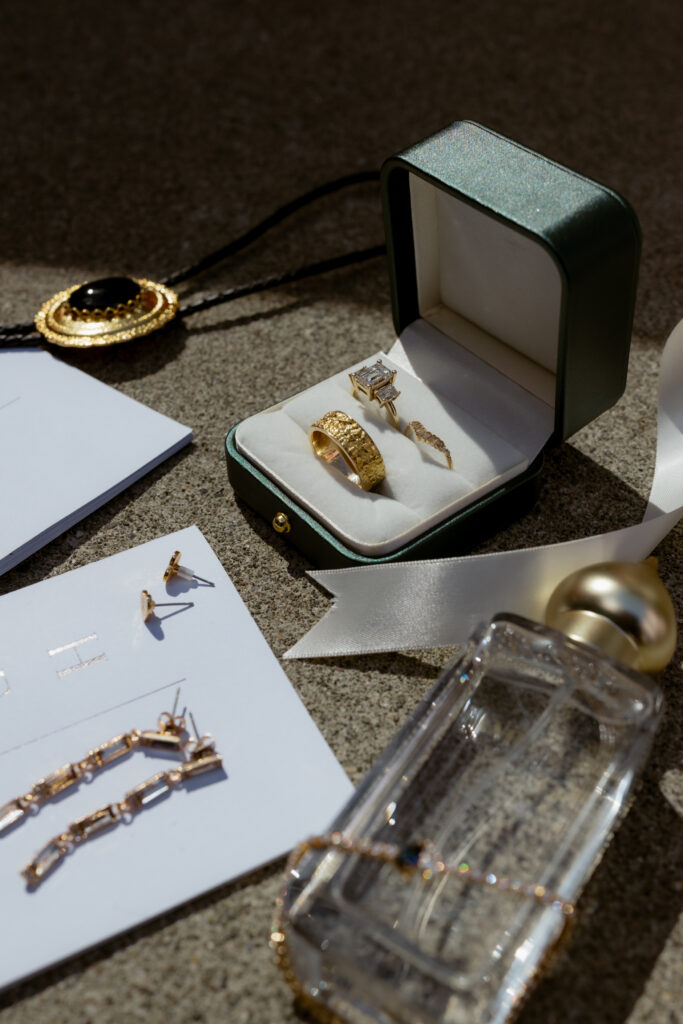 Wedding detail photos including engagement ring, bolo tie, earrings, and perfume.