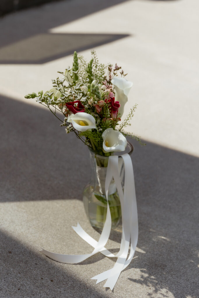 Wedding bouquet in vase with light shinning on it.