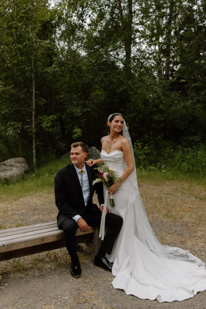 Bride and groom posing near the forest during wedding portraits