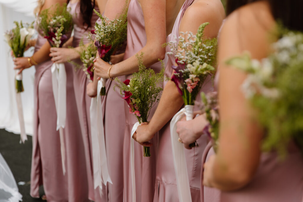 Close up of bridesmaids bouquets as they stand at the altar.