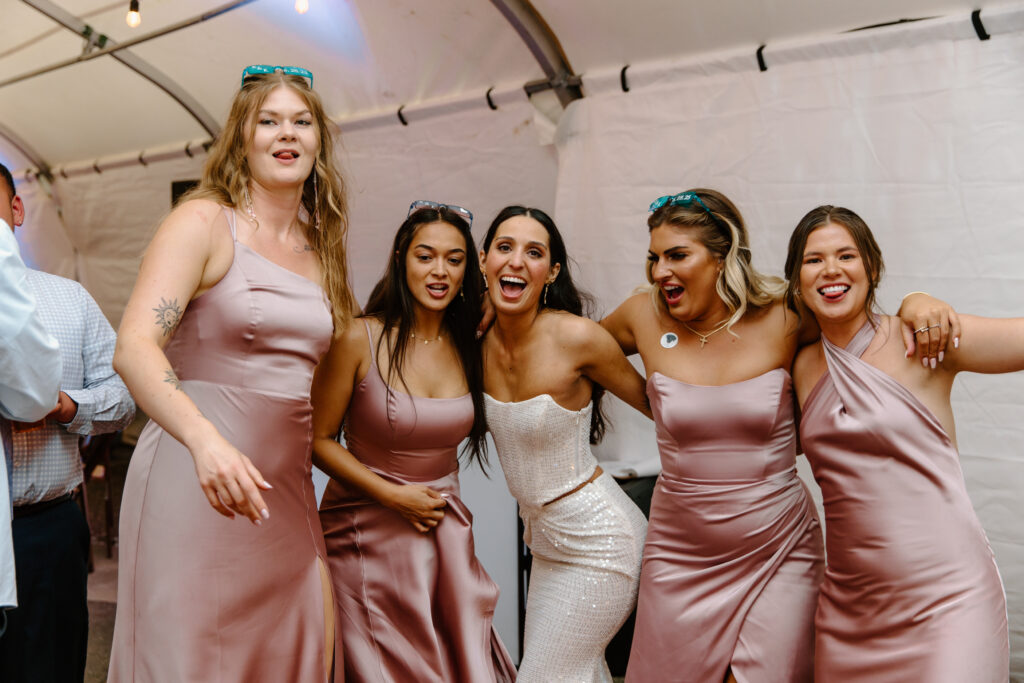 Bride and bridesmaids lined up celebrating during the reception at the Alaska Native Heritage Center wedding in Anchorage Alaska