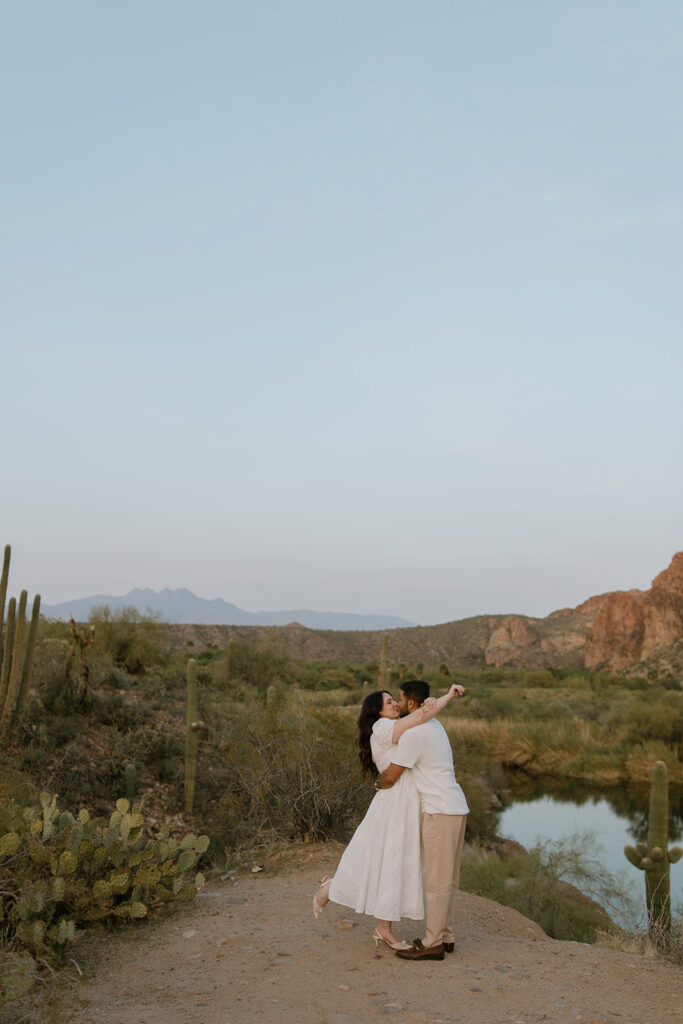 Couple kissing at the overlook with desert mountain views behind them at the Salt River