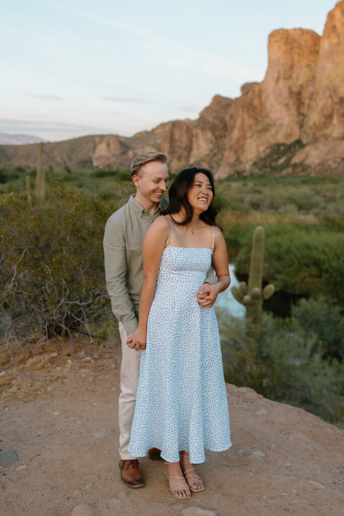 Couple embracing and smiling together at the Salt River during an Arizona engagement session